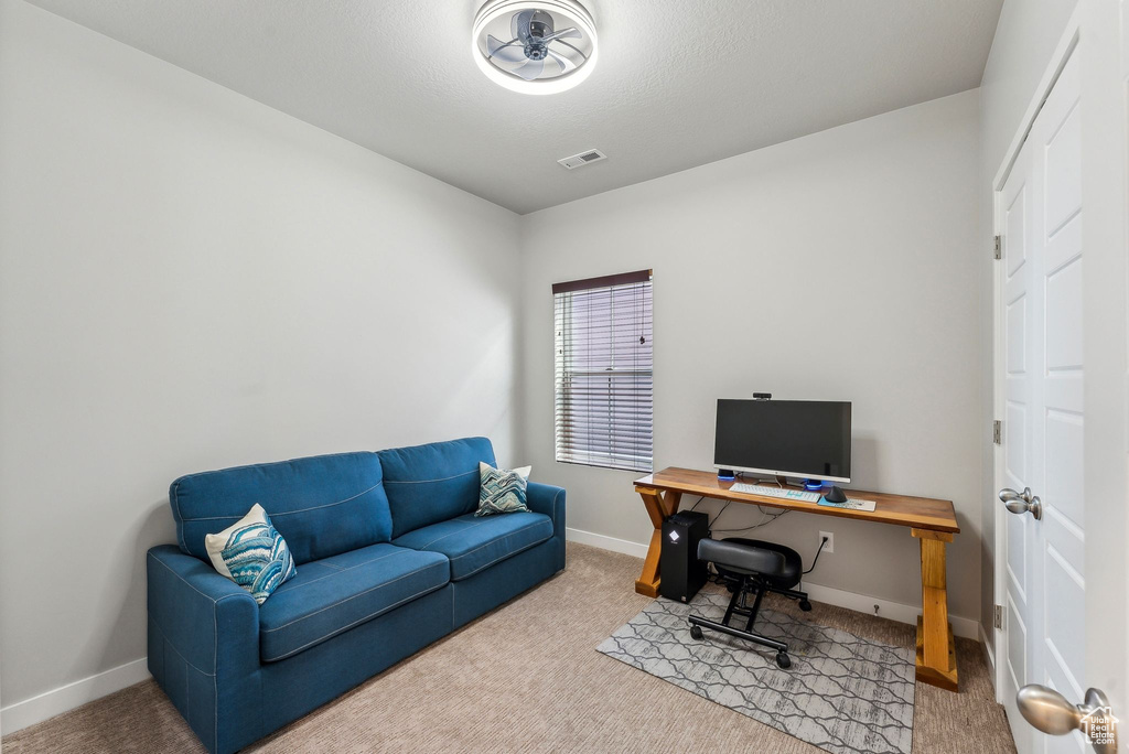Home office featuring baseboards, visible vents, and carpet