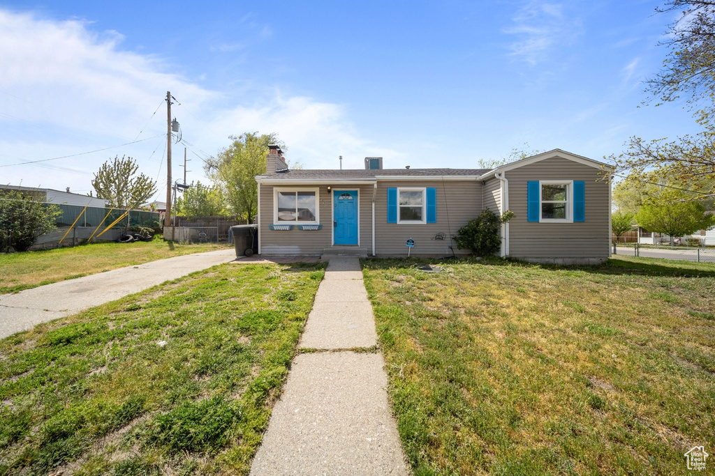Bungalow featuring a chimney, fence, and a front yard
