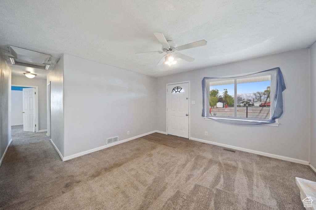 Unfurnished room with visible vents, carpet flooring, baseboards, and a ceiling fan
