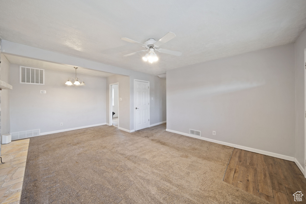 Spare room featuring baseboards, visible vents, and ceiling fan with notable chandelier