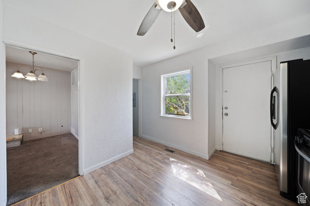 Foyer entrance with baseboards, ceiling fan, visible vents, and wood finished floors