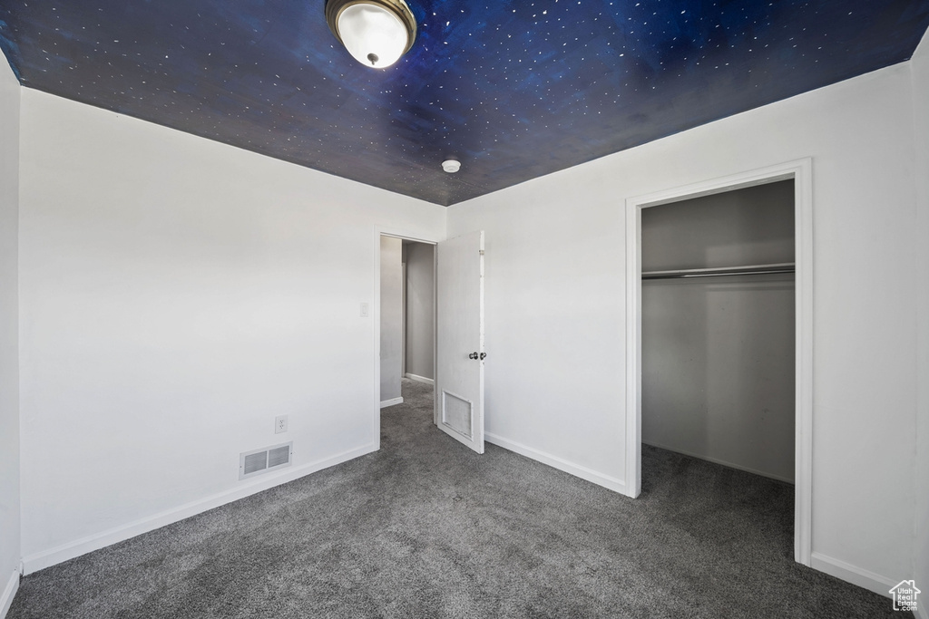Unfurnished bedroom featuring carpet floors, baseboards, visible vents, and a closet