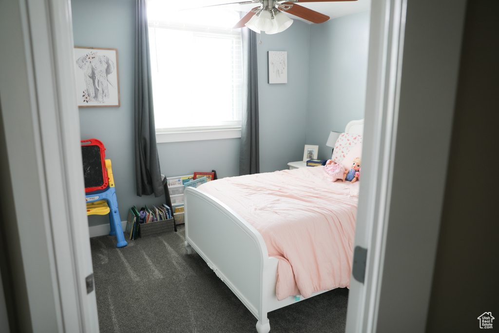 Bedroom featuring dark carpet and a ceiling fan