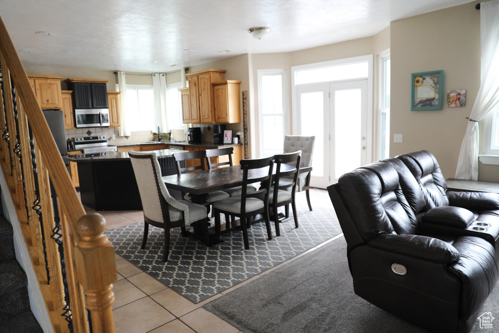 Dining room featuring light tile patterned floors and stairway