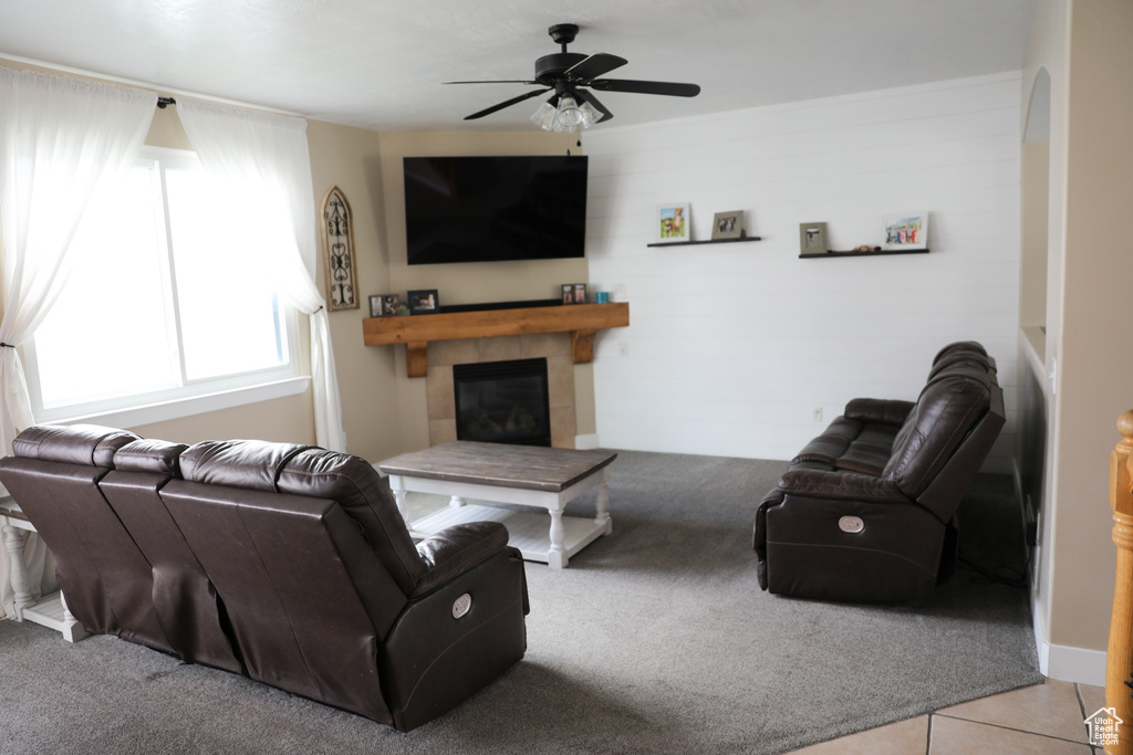 Living room with a ceiling fan, a fireplace, and carpet flooring