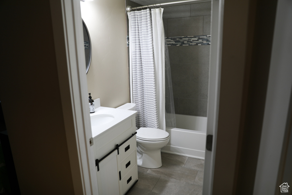 Bathroom with vanity, shower / bathtub combination with curtain, and toilet