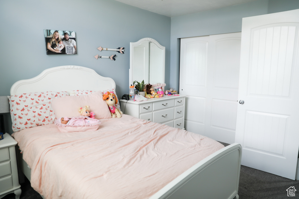 Bedroom with dark carpet and a closet