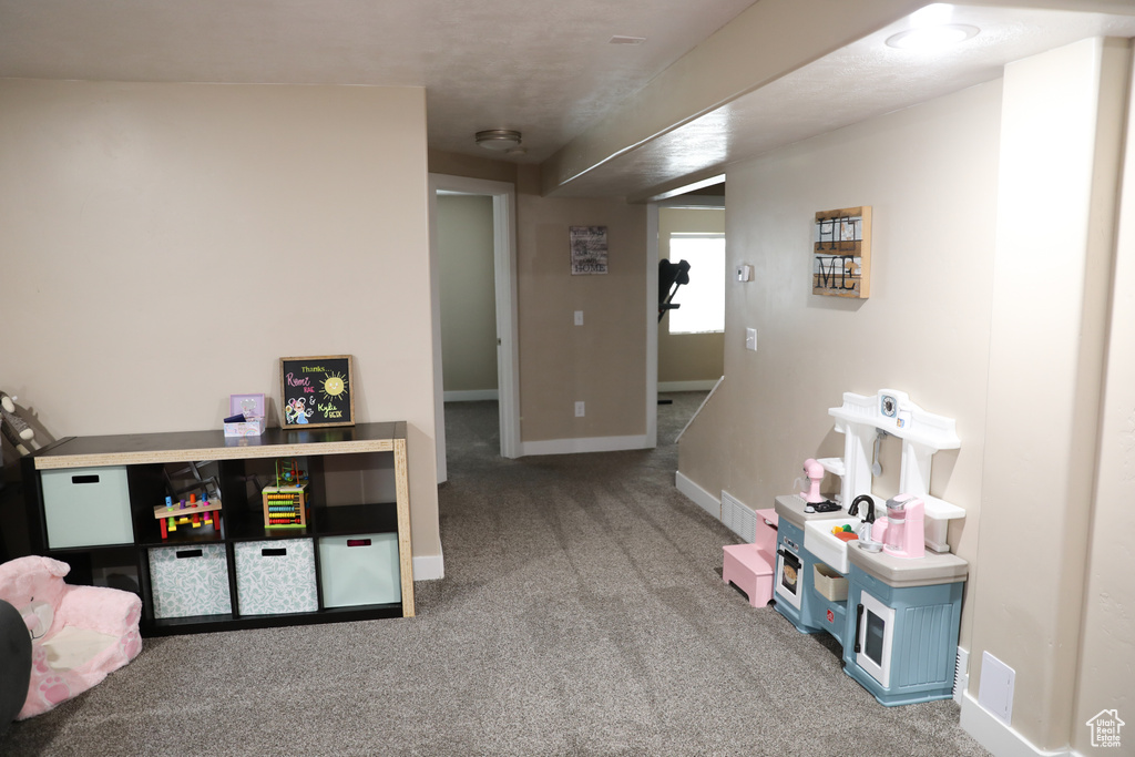 Recreation room featuring baseboards and carpet flooring