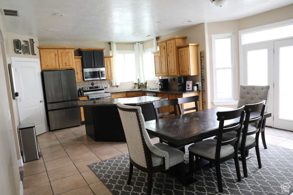 Dining space with light tile patterned flooring and visible vents