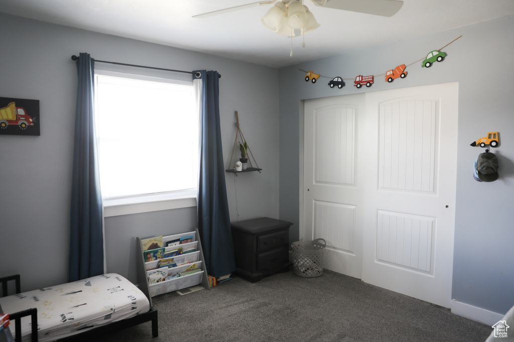 Carpeted bedroom featuring multiple windows, a closet, and ceiling fan