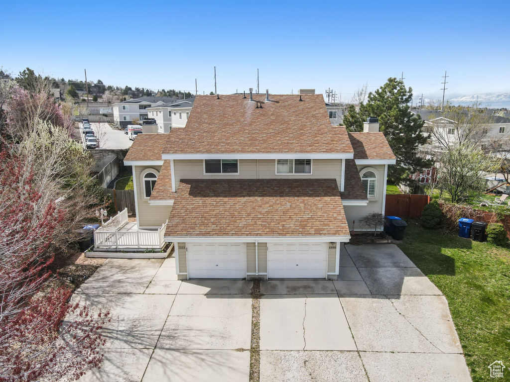 View of front facade with a garage, fence, roof with shingles, a chimney, and concrete driveway