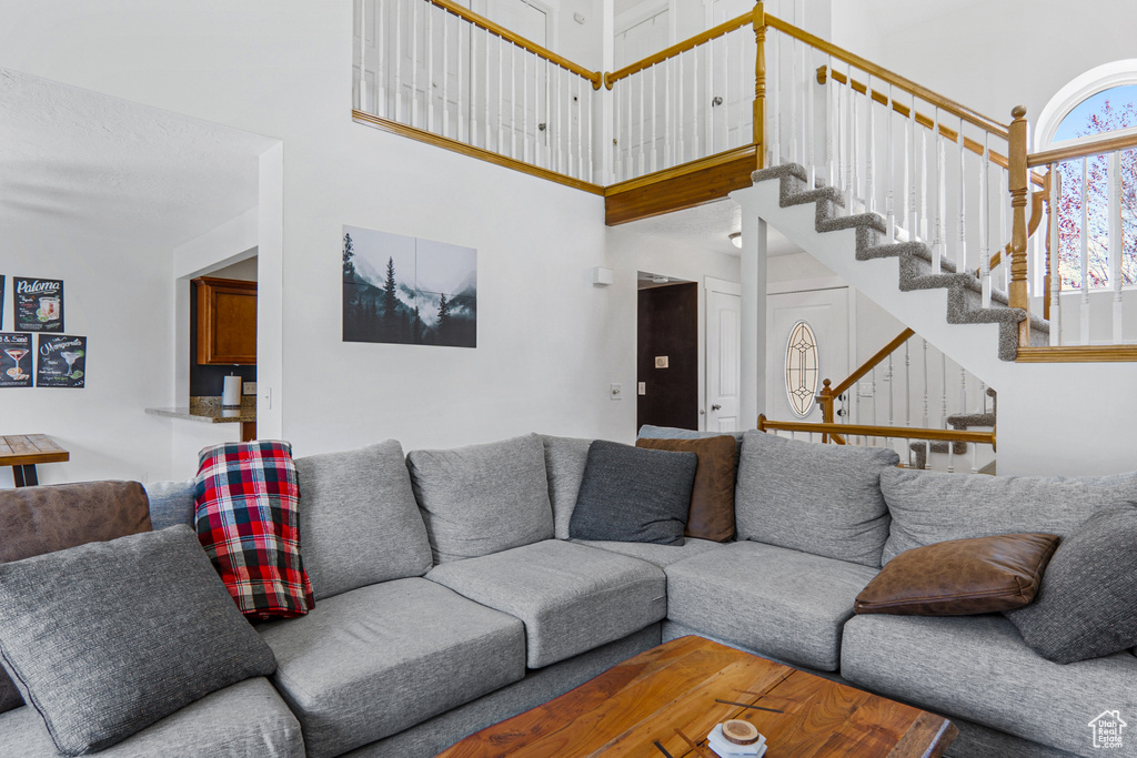 Living area featuring a towering ceiling and stairway