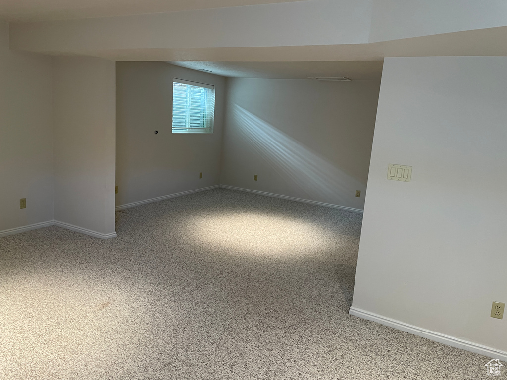 Carpeted empty room featuring baseboards