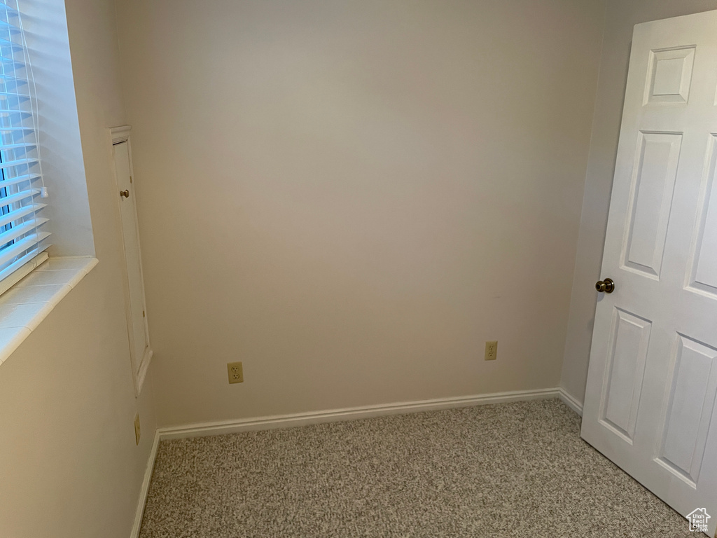 Carpeted spare room featuring baseboards
