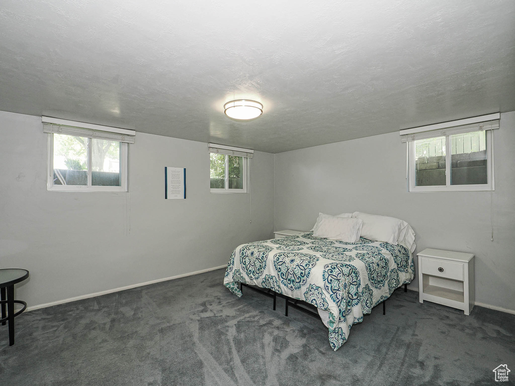 Bedroom featuring baseboards, carpet, and a textured ceiling