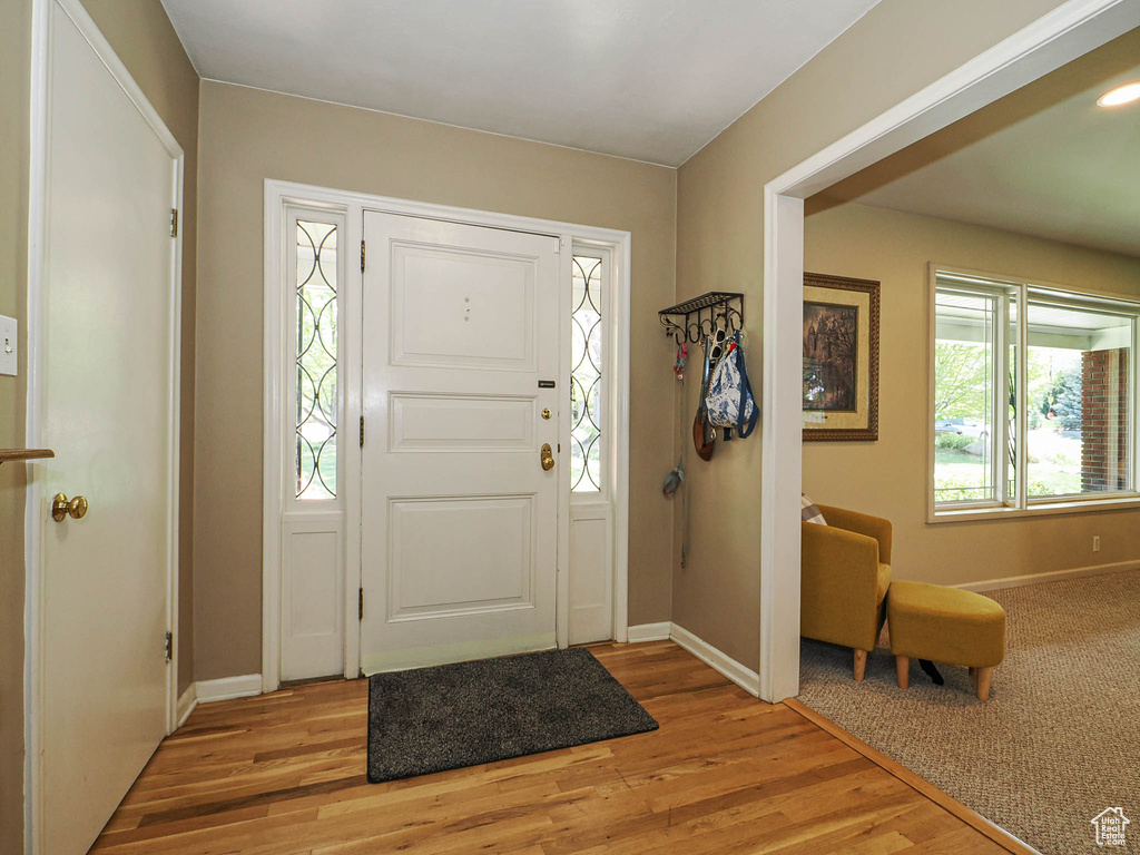 Entryway with baseboards and light wood finished floors