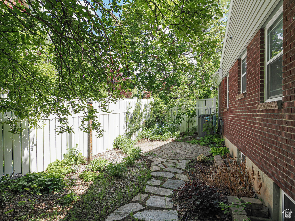 View of yard with fence and central AC unit