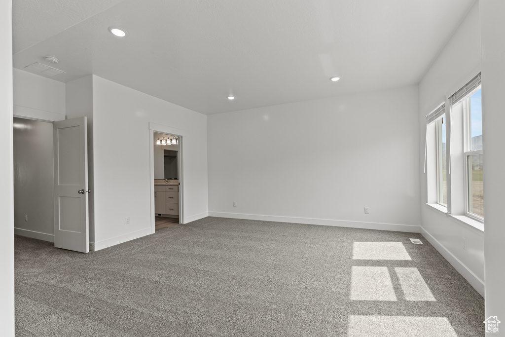 Unfurnished room featuring recessed lighting, baseboards, and dark carpet