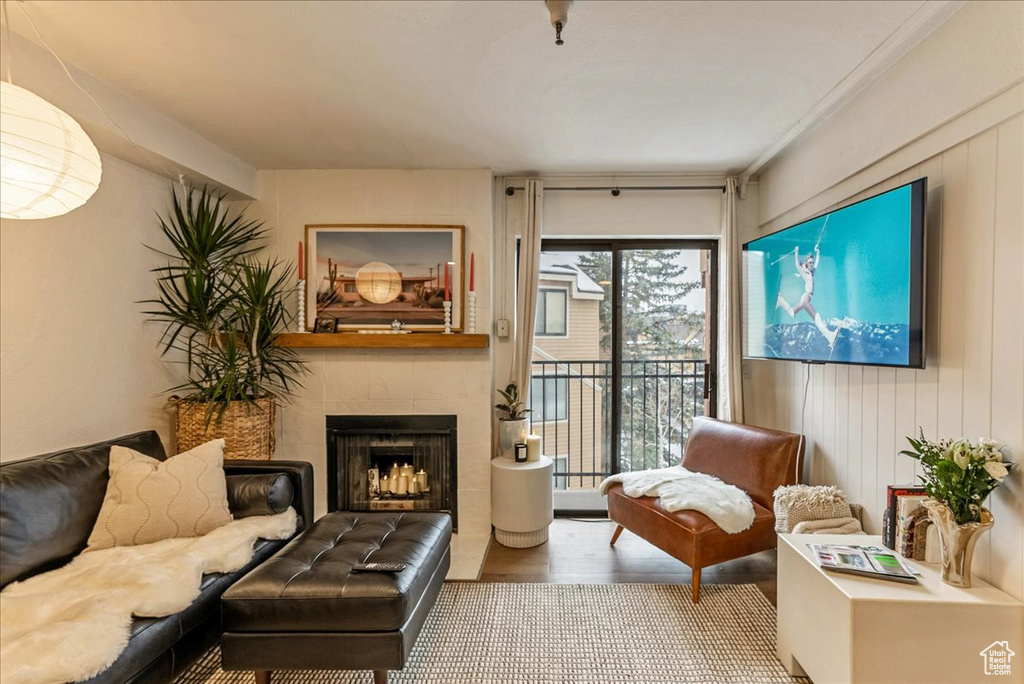 Sitting room with wood finished floors and a tile fireplace