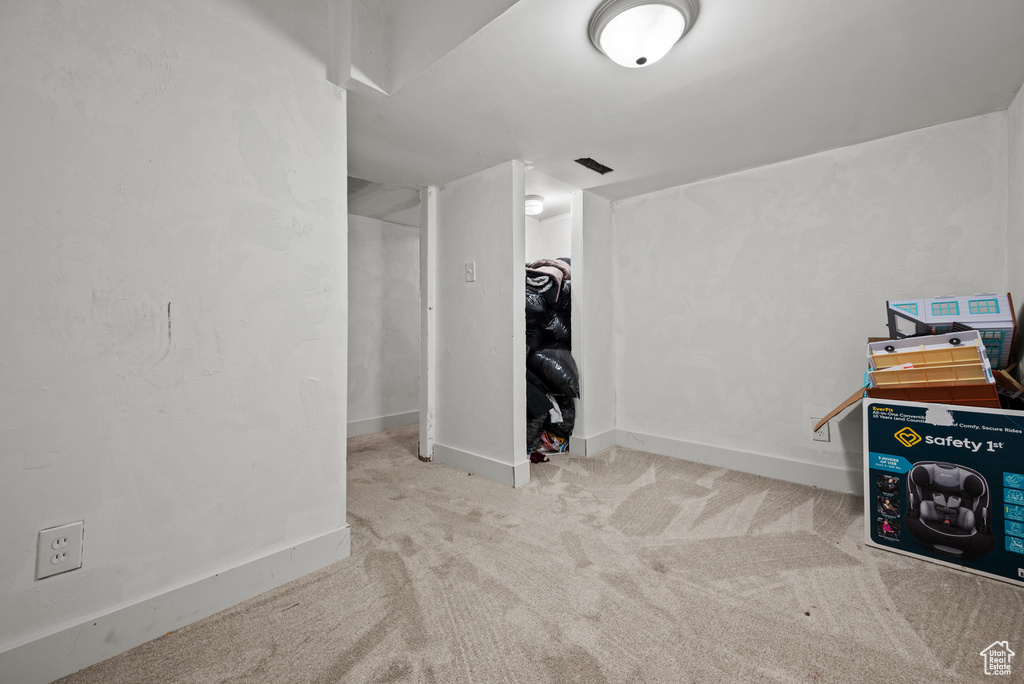 Basement featuring baseboards and carpet