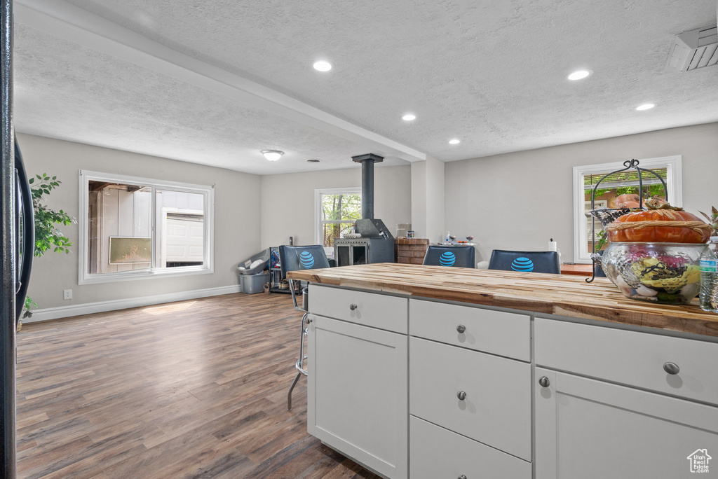 Kitchen with wooden counters, dark wood-style floors, a textured ceiling, and open floor plan