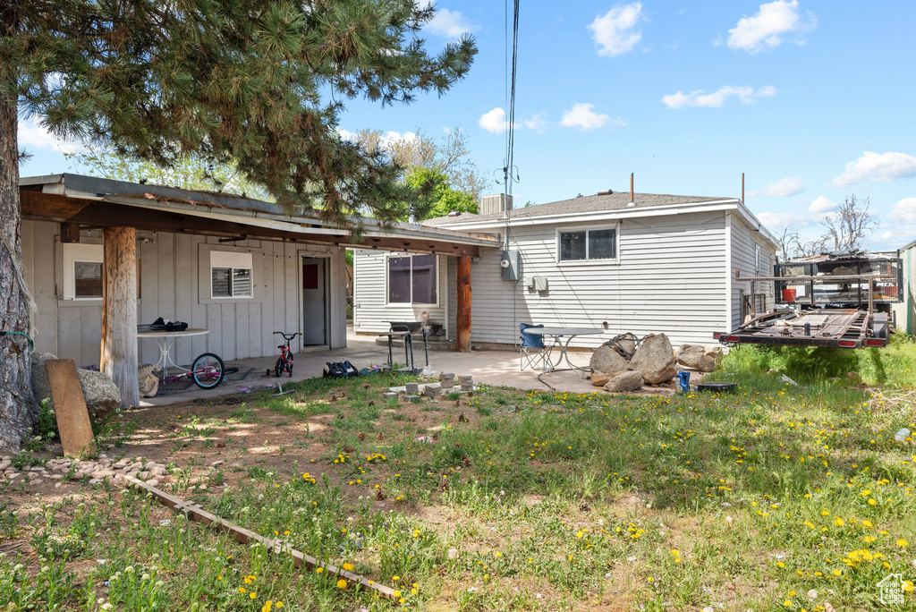 Rear view of property with board and batten siding and a patio area