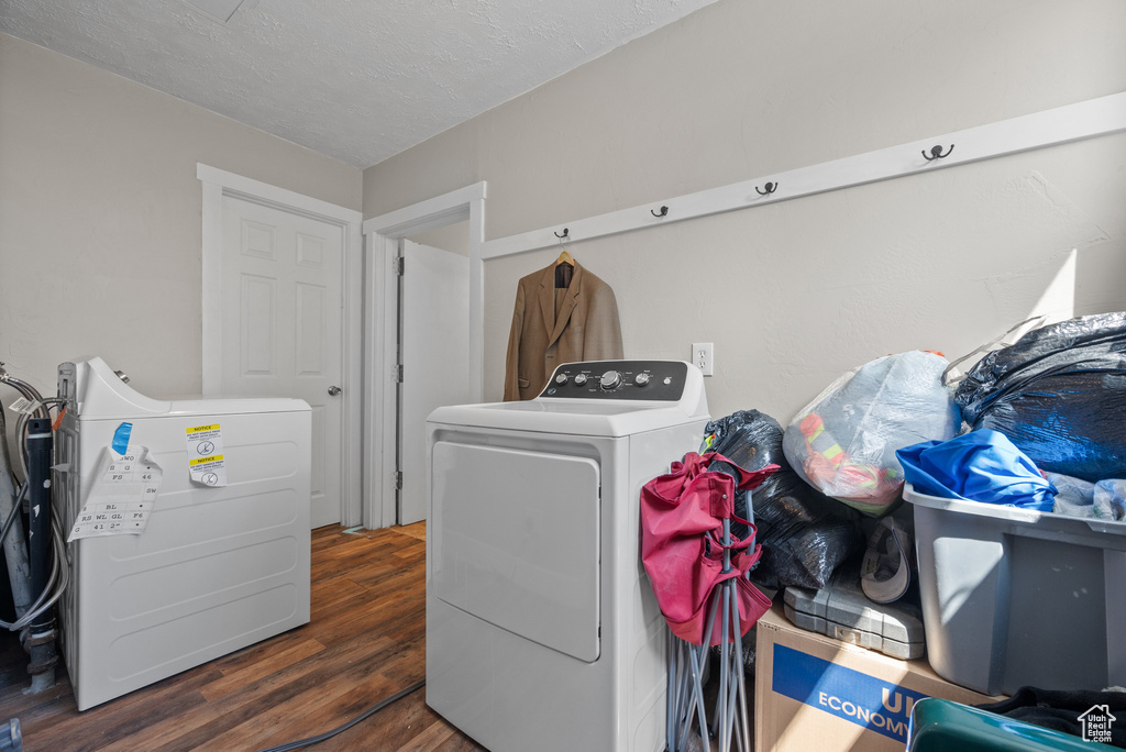 Laundry area with separate washer and dryer, laundry area, wood finished floors, and a textured ceiling