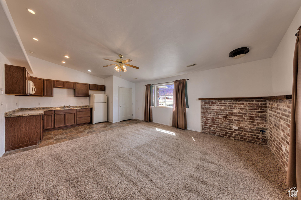 Unfurnished living room featuring recessed lighting, a sink, a ceiling fan, light carpet, and lofted ceiling