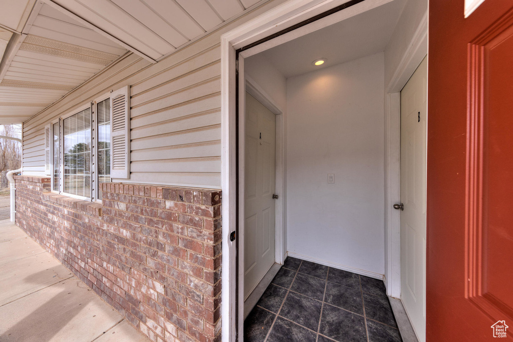 Property entrance with a porch and brick siding