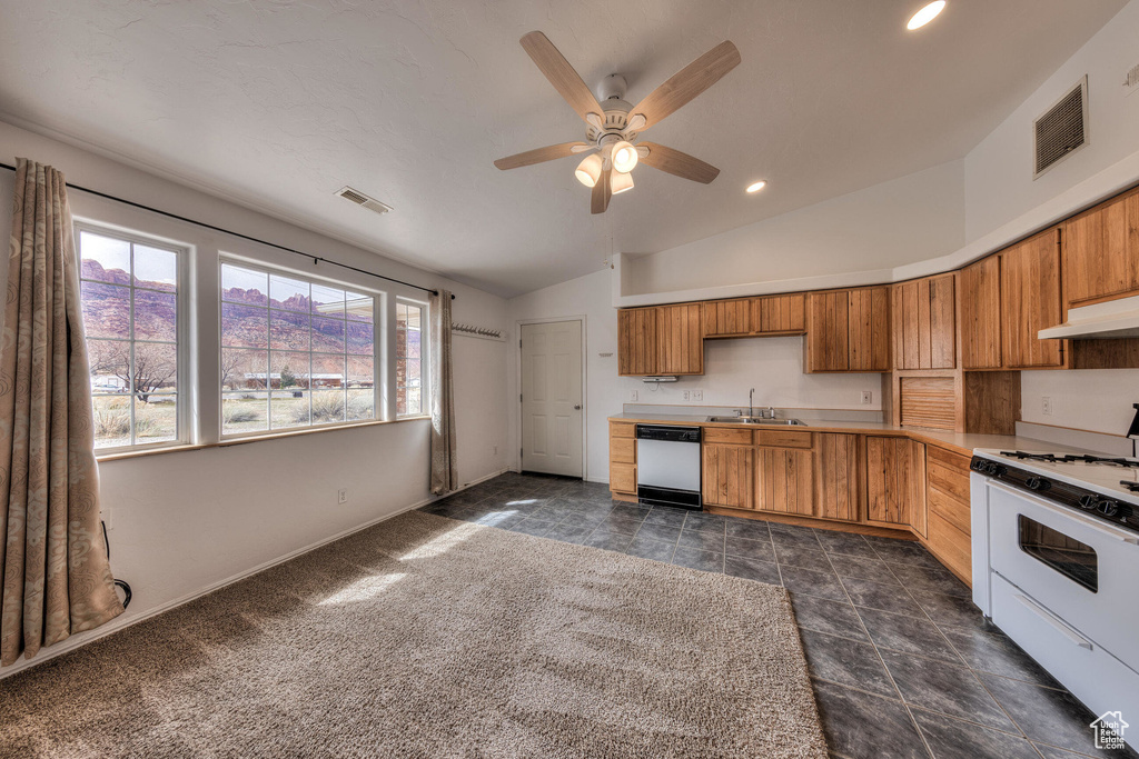 Kitchen featuring white appliances, under cabinet range hood, a sink, visible vents, and lofted ceiling