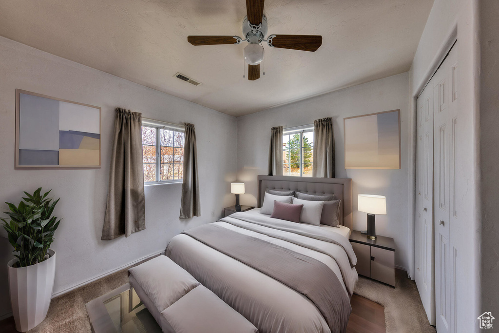 Bedroom with visible vents, ceiling fan, a closet, and multiple windows
