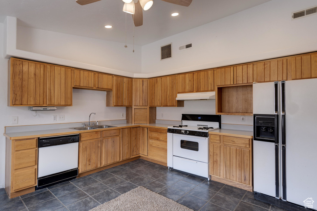 Kitchen featuring visible vents, a sink, under cabinet range hood, and white appliances