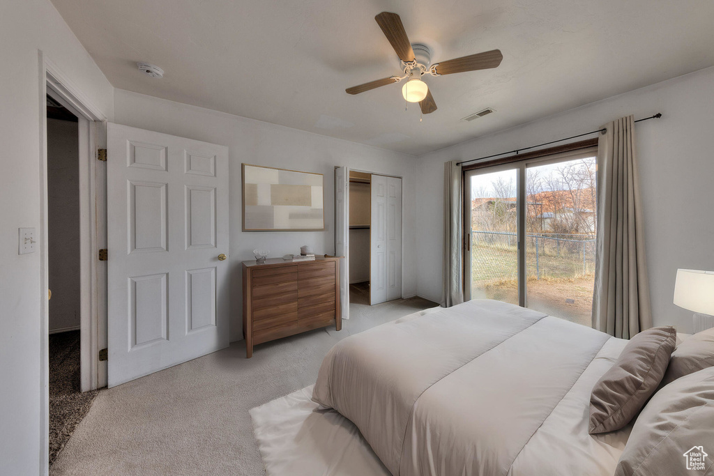 Bedroom featuring visible vents, ceiling fan, a closet, and light carpet
