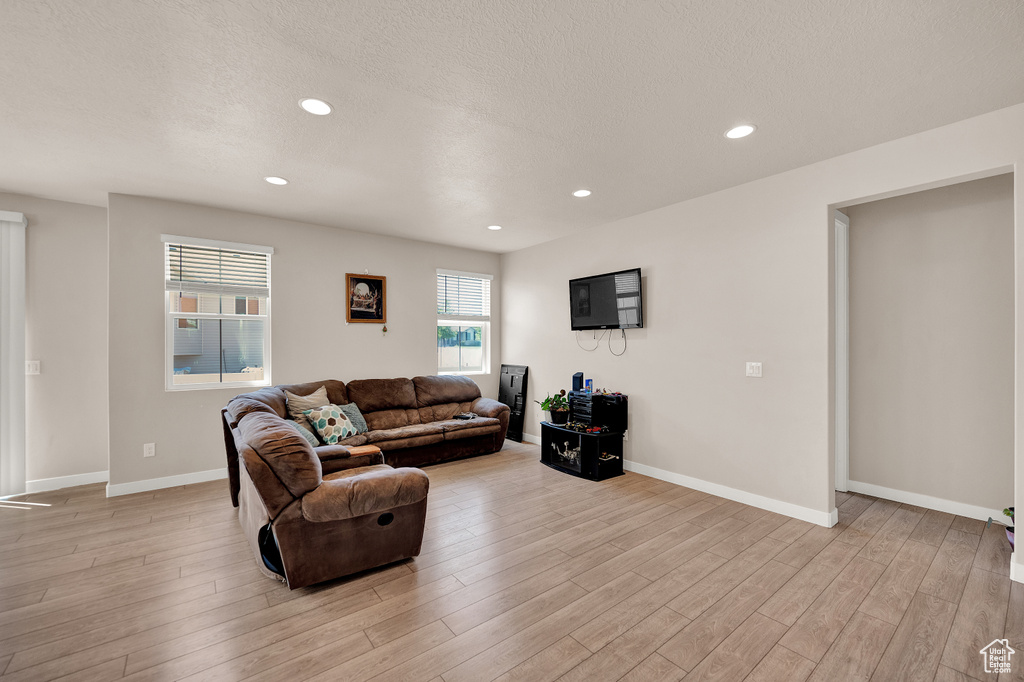 Living room featuring recessed lighting, baseboards, and light wood-style flooring