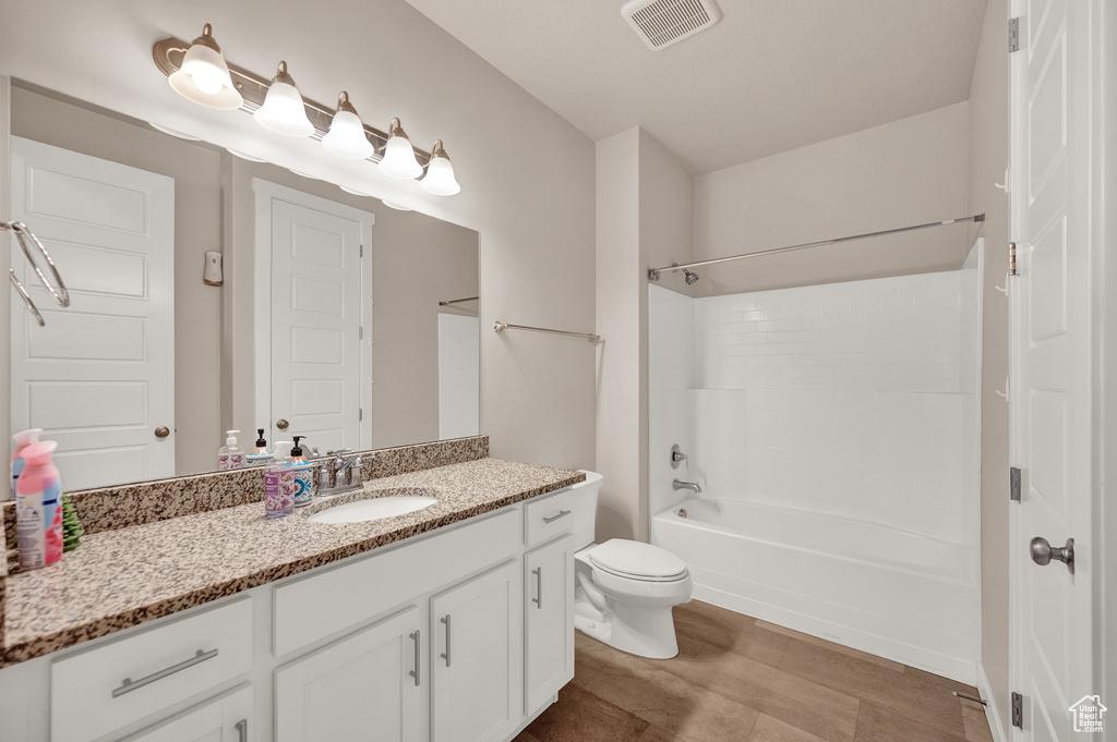 Full bathroom with toilet, visible vents, shower / washtub combination, and vanity