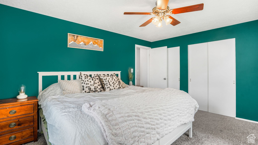 Carpeted bedroom featuring two closets and ceiling fan