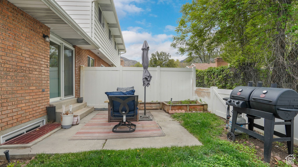 View of patio / terrace with entry steps, fence, and a grill