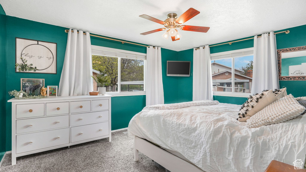 Carpeted bedroom with baseboards and a ceiling fan