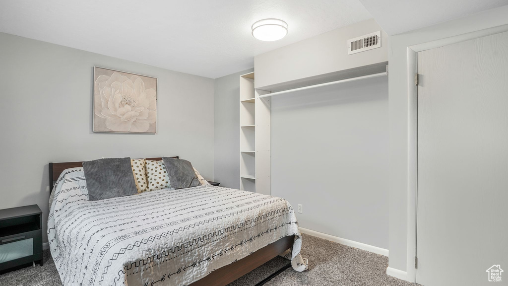 Bedroom with visible vents, carpet, and baseboards