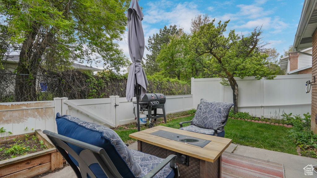 View of patio with a fenced backyard and area for grilling