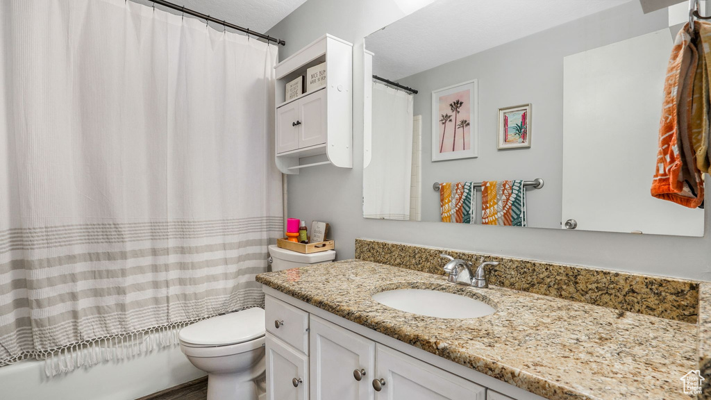 Full bath with vanity, toilet, and shower / tub combo