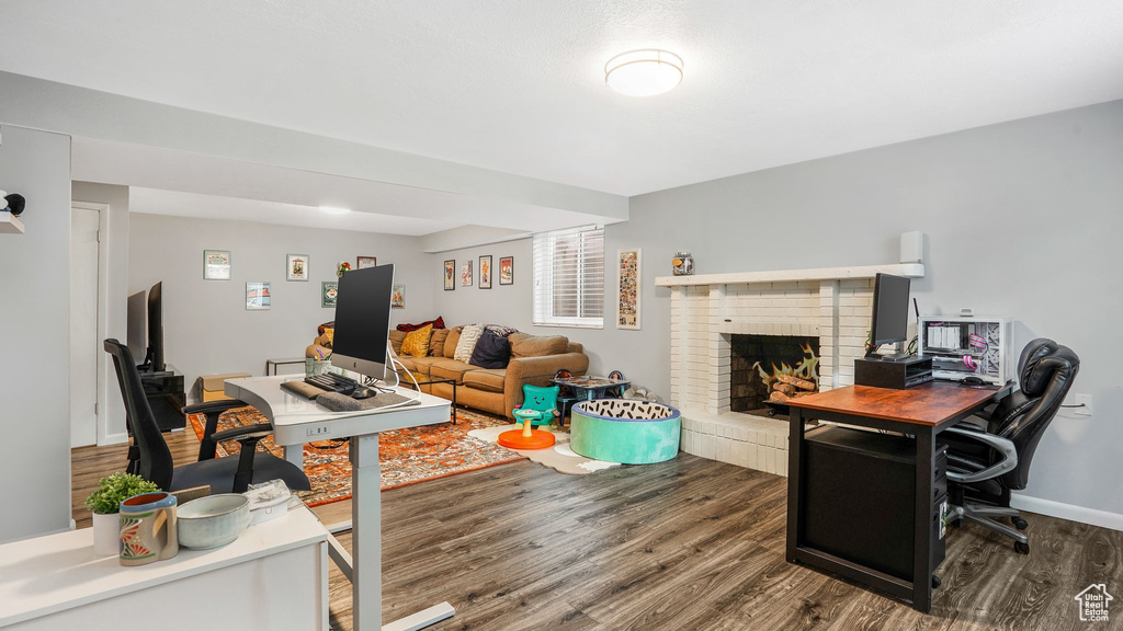 Living room with baseboards, a fireplace, and wood finished floors