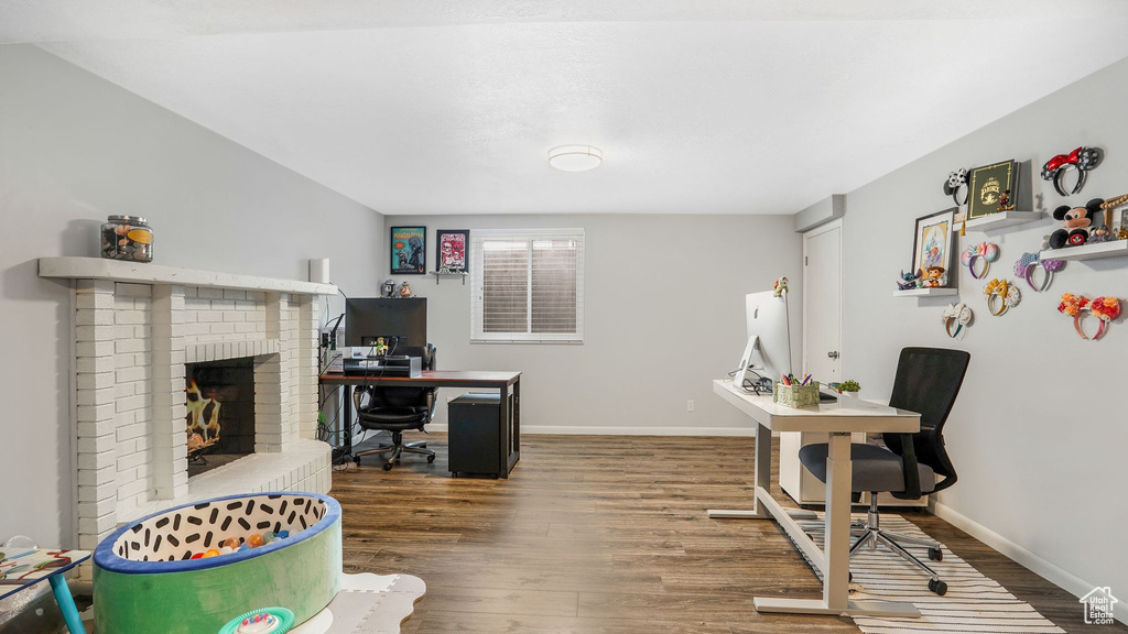 Office with baseboards, wood finished floors, and a fireplace