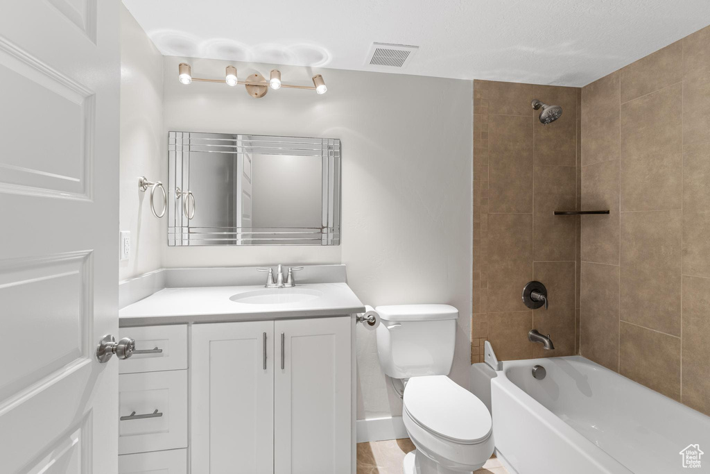 Full bath featuring visible vents, bathing tub / shower combination, toilet, and vanity