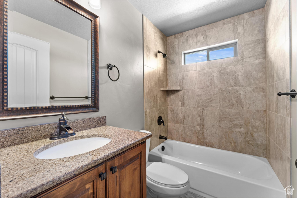 Full bathroom with vanity, shower / bathtub combination, and toilet