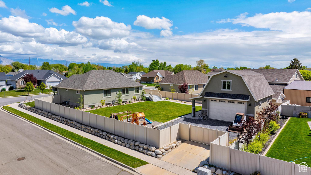 View of front of house with driveway, a residential view, fence private yard, and a garage