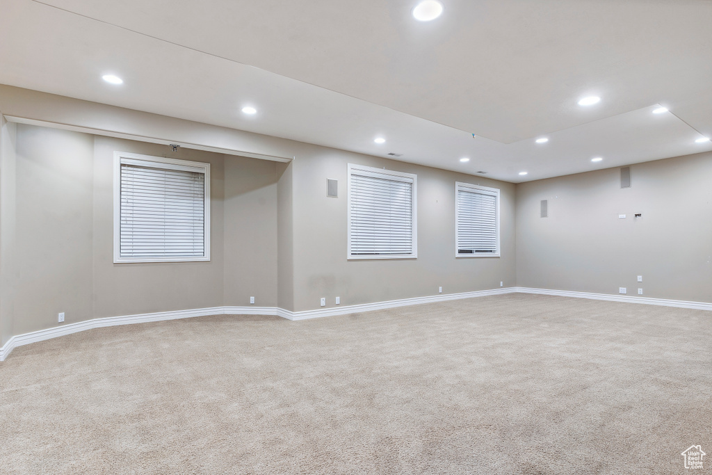Basement with baseboards, recessed lighting, and light colored carpet