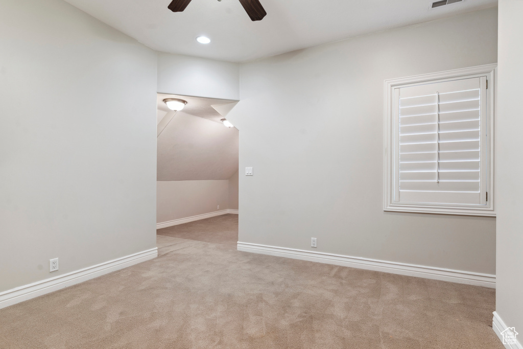 Spare room featuring carpet flooring, ceiling fan, visible vents, and baseboards