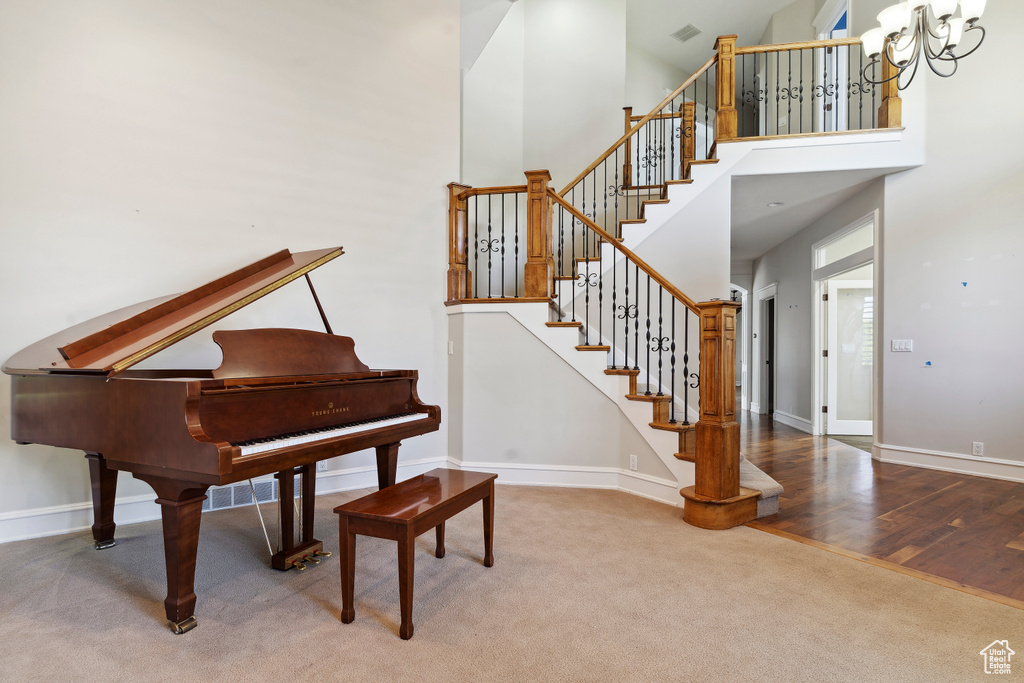 Interior space with baseboards, carpet, a towering ceiling, and visible vents
