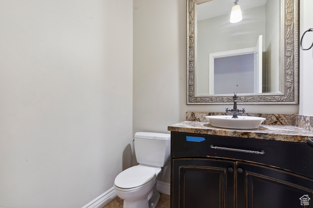 Bathroom featuring vanity, baseboards, and toilet